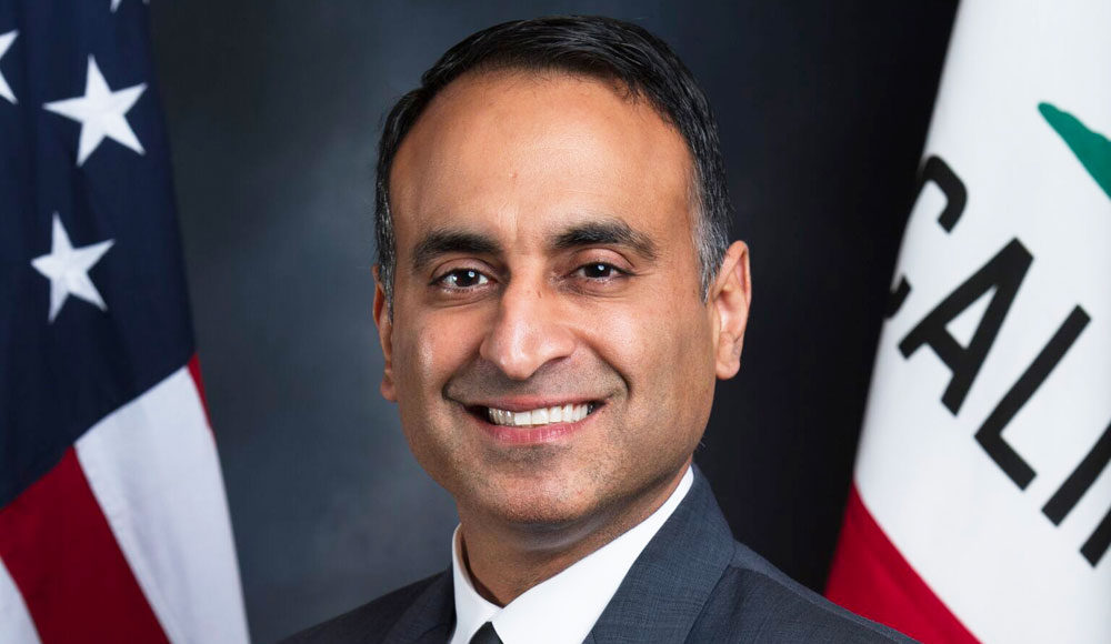 Portrait of assemblymember in front of American and California flags