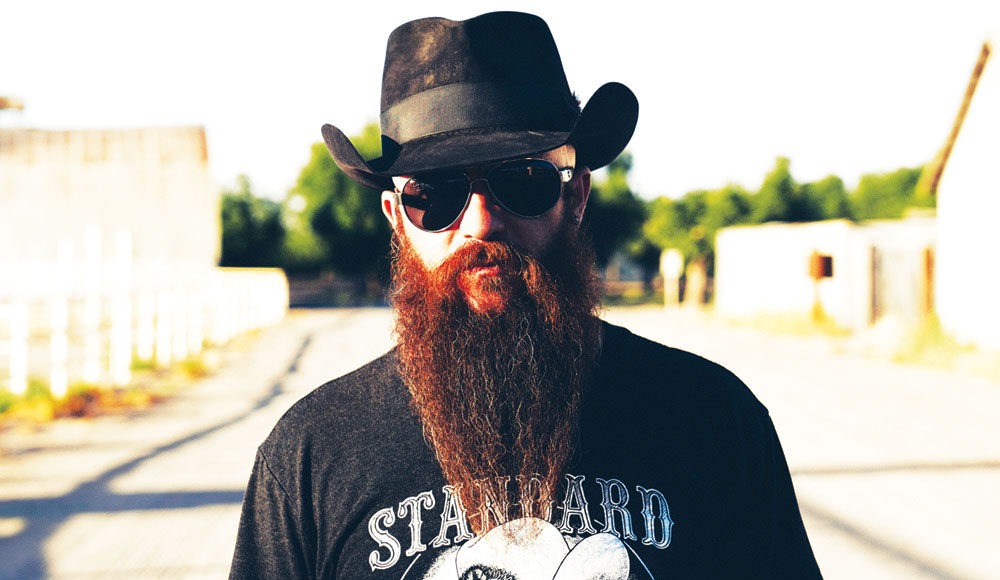 Man with a long beard wearing a black hat and black T-shirt