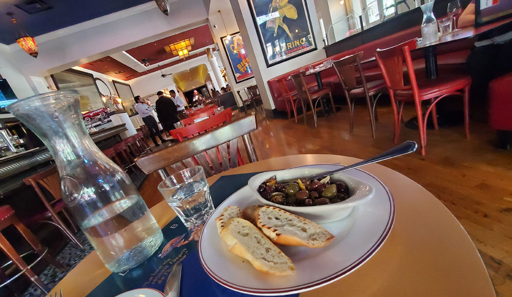 Plate of olives with a restaurant interior in the background