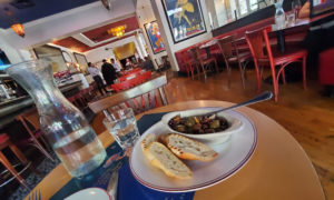 Plate of olives with a restaurant interior in the background