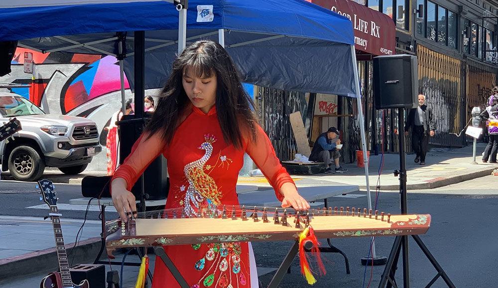 Woman playing musical instrument on a city street