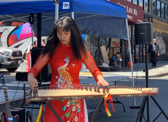 Woman playing musical instrument on a city street