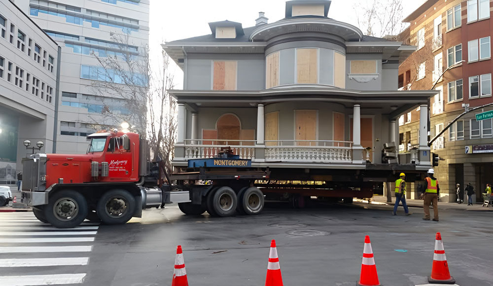 Old house being moved on the back of a flatbed truck