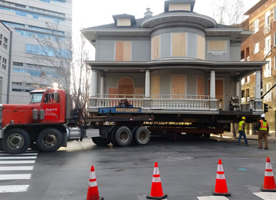 Old house being moved on the back of a flatbed truck