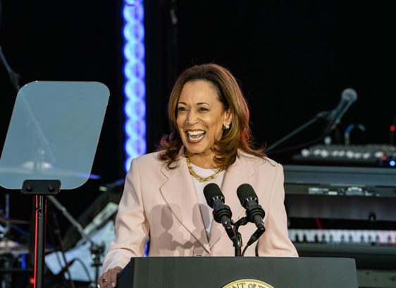 Kamala Harris speaking into a microphone at a podium