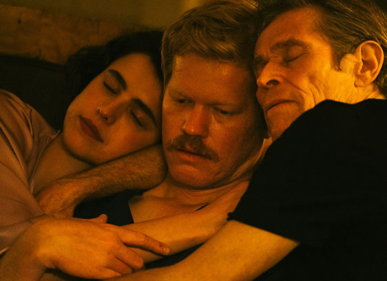 Three actors holding each other closely, appearing to be in bed