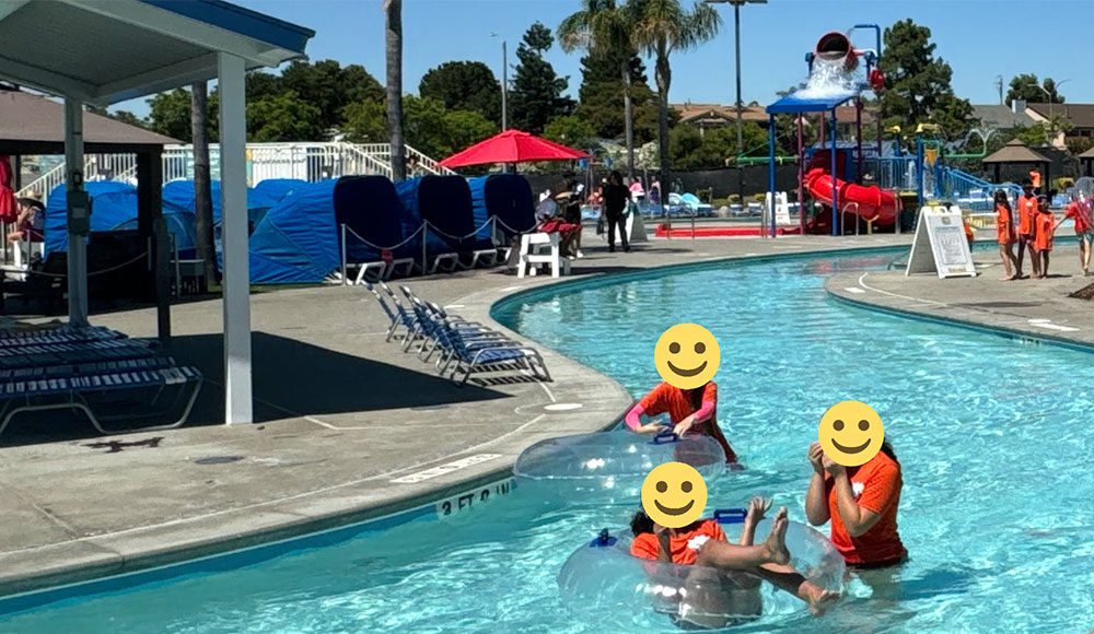 Photo of people at a water park with smiley-face heads grafted onto the bodies