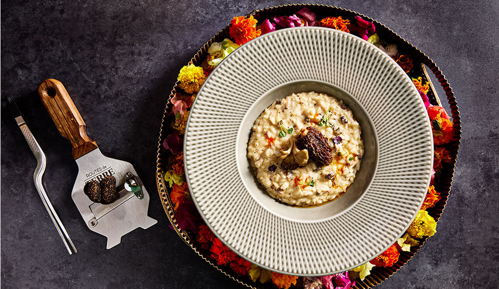 Beautiful round dish with food inside and decorative flowers around the edges