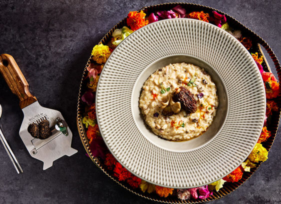 Beautiful round dish with food inside and decorative flowers around the edges