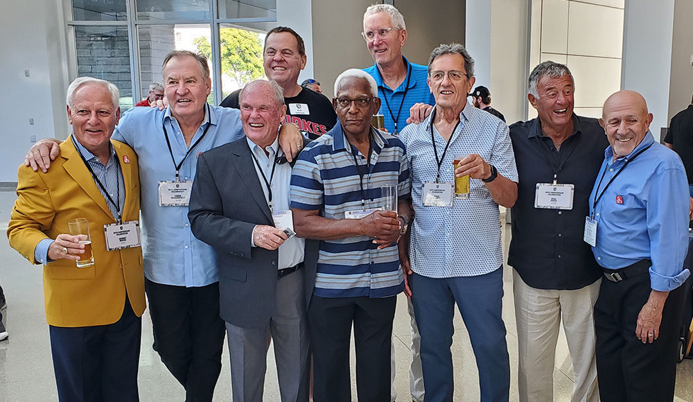 Group of nine men posing for a photograph