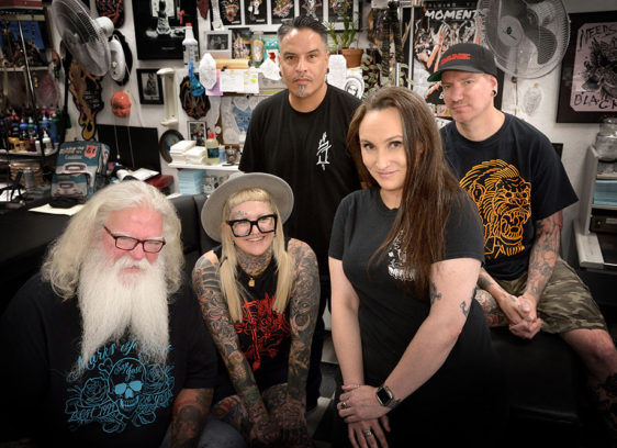 Group of five people in a tattoo shop