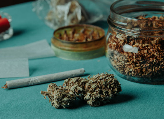 Marijuana buds and a joint sitting on a tabletop