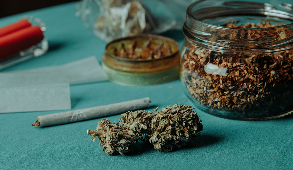 Marijuana buds and a joint sitting on a tabletop