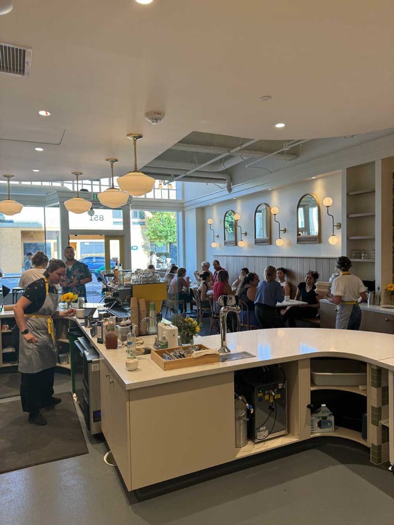 The interior of the bakery looking from the back toward the large windows in the front.