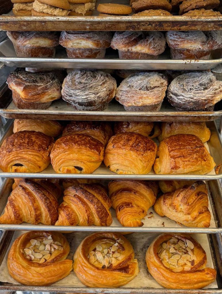 Six rows of various types of pastries on cooling racks