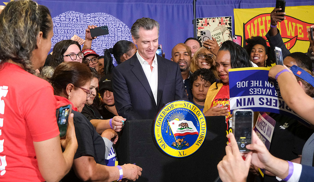 California governor at podium surrounded by a crowd