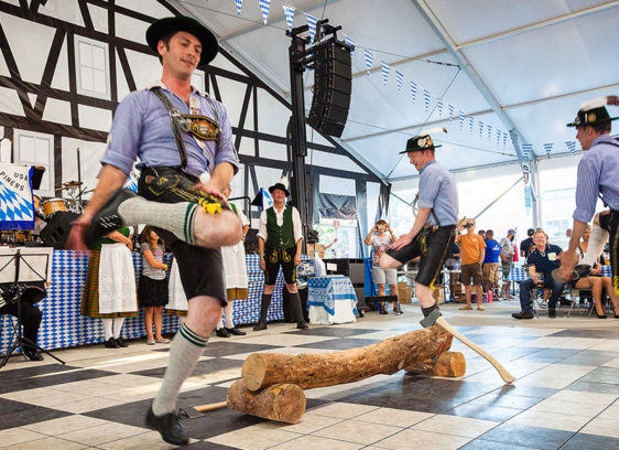 Men wearing lederhosen jumping in a circle