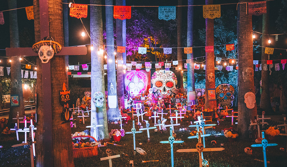 Brightly colored decorations for Day of the Dead, lit up at night