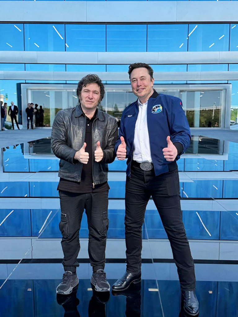 Two men standing in front of a large office building