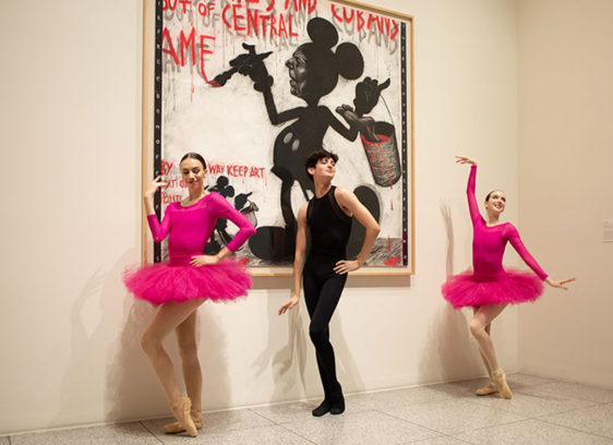 Three dancers in front of an abstract painting