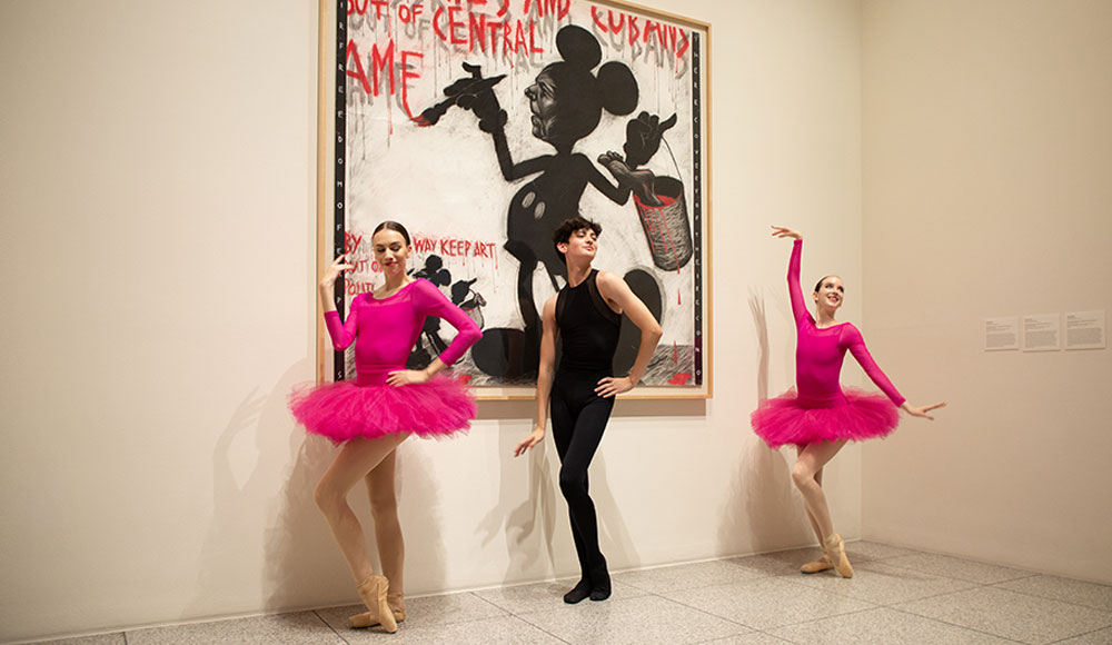 Three dancers in front of an abstract painting