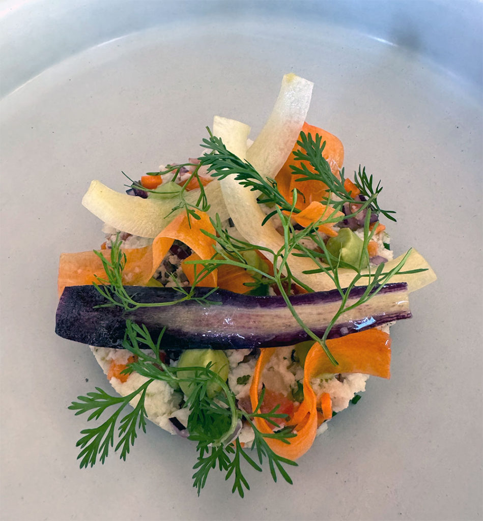 Carrots and herbs on a bed of some sort of grain