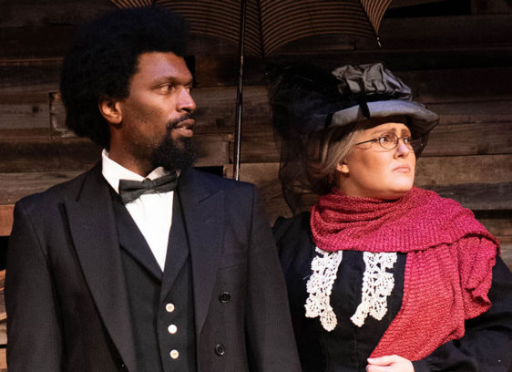 Black man and white woman in 19th century clothing on a stage