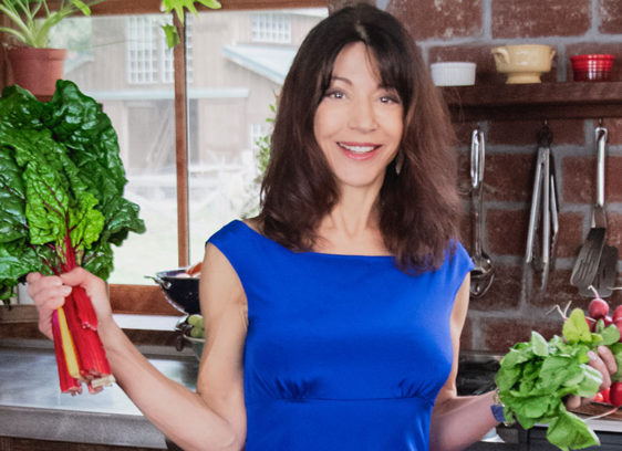 Woman in a kitchen holding produce