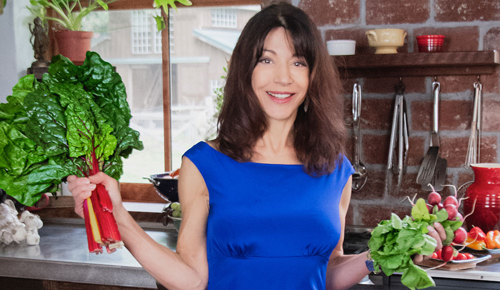 Woman in a kitchen holding produce