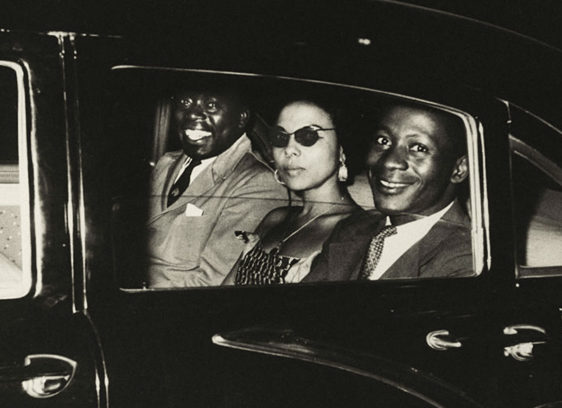 Black-and-white retro photograph of three people in a car