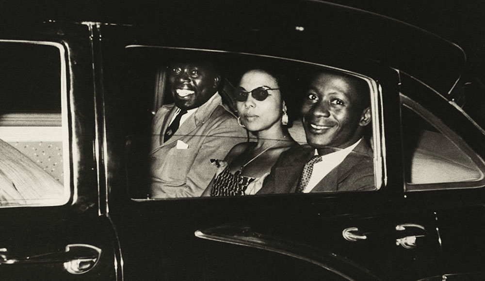 Black-and-white retro photograph of three people in a car