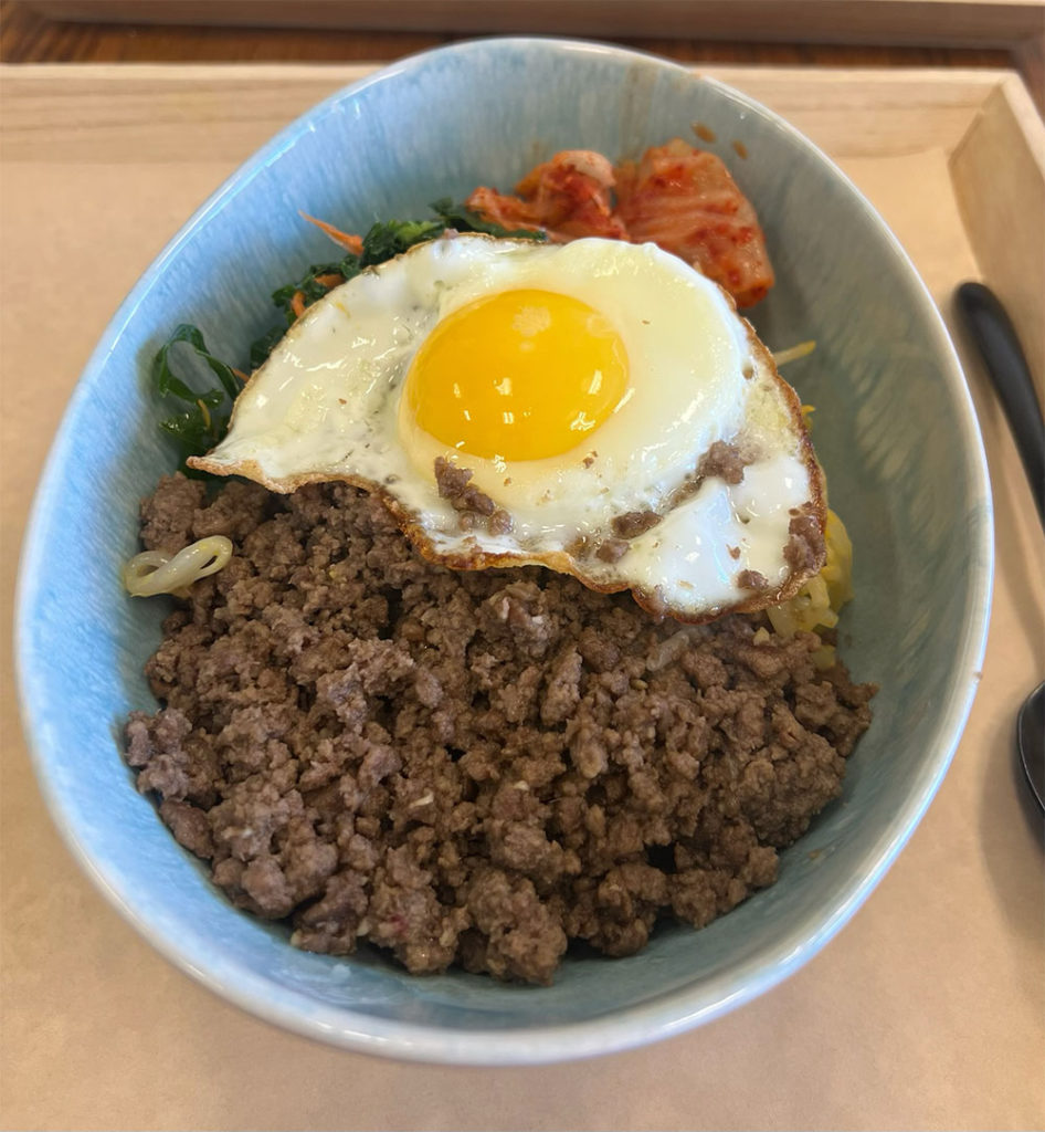 Bowl of food topped with a fried egg