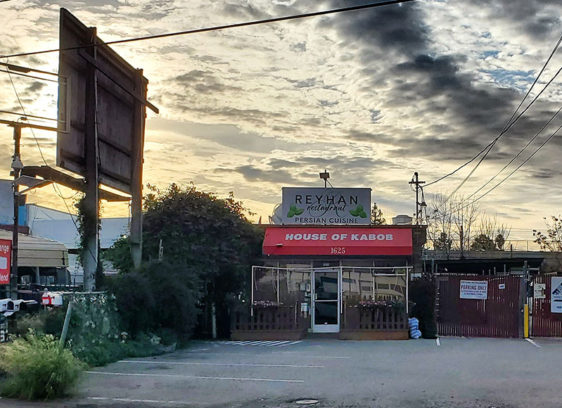 Kabob restaurant in an industrial area under a dramatic cloudy sky