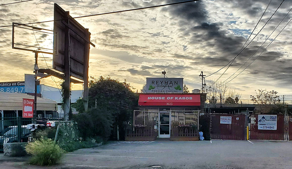 Kabob restaurant in an industrial area under a dramatic cloudy sky