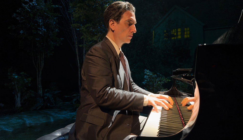 Man playing a piano onstage