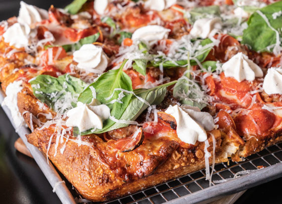 Closeup of a fully loaded pizza in a square pan