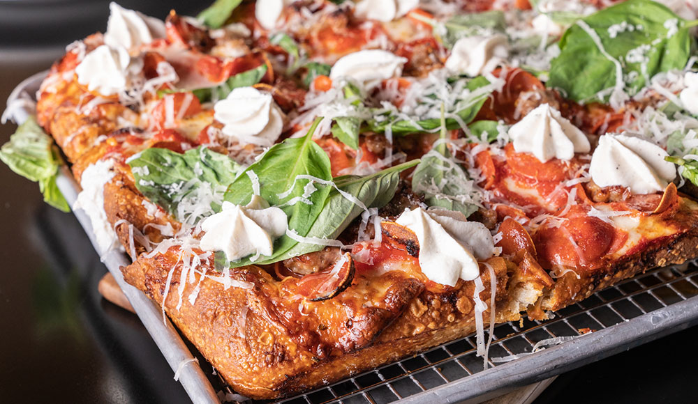 Closeup of a fully loaded pizza in a square pan