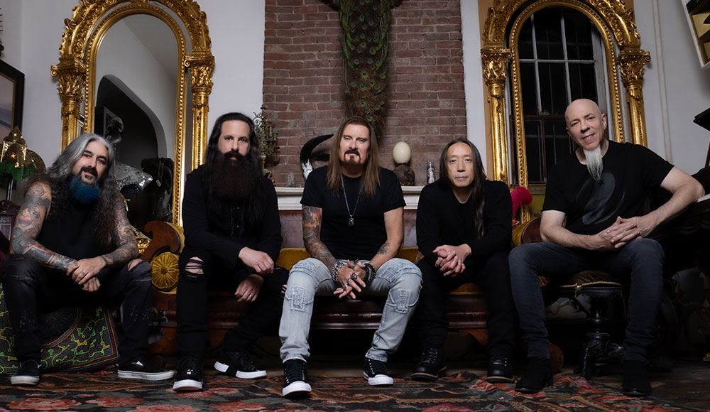 Band photo of five men on a couch in an ornate room