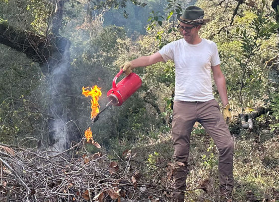 Man starting a bonfire in the forest