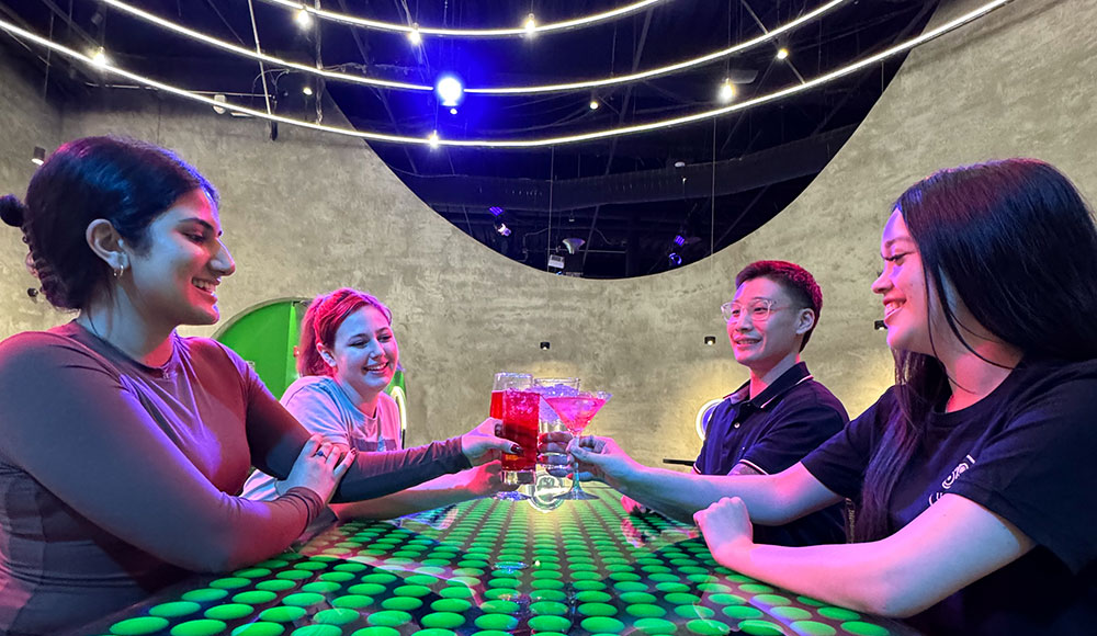 Group of four young adults sitting around a table in a brightly colored lounge